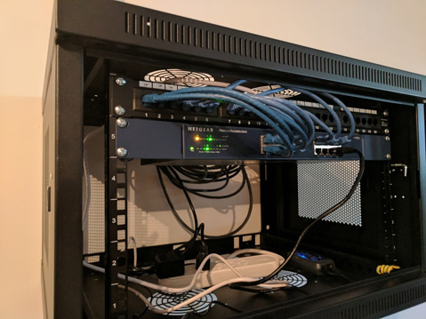 Photo of rack mounted equipment, ethernet ports on switch connected to patch panel